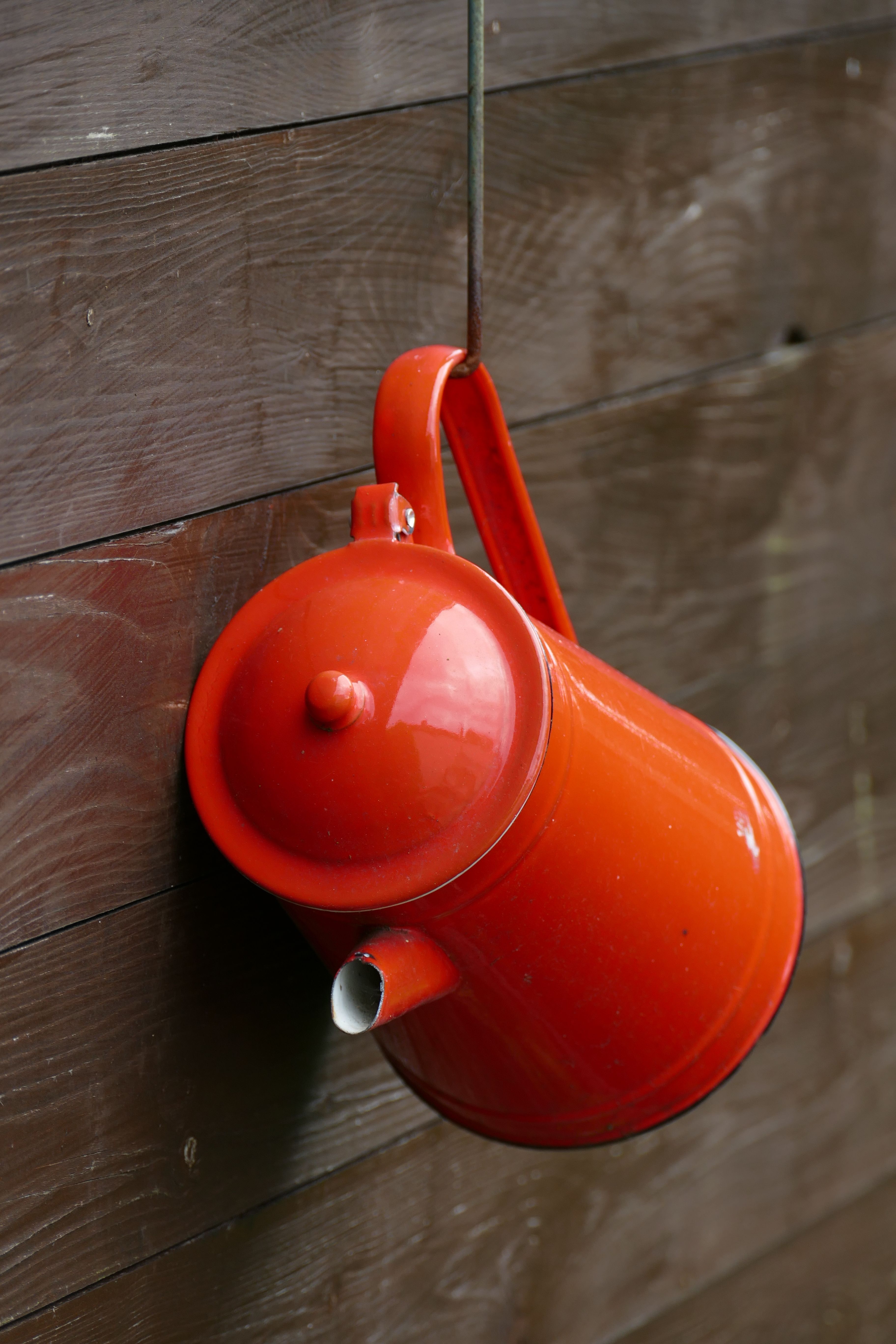 Red air pump hanging on a wooden wall